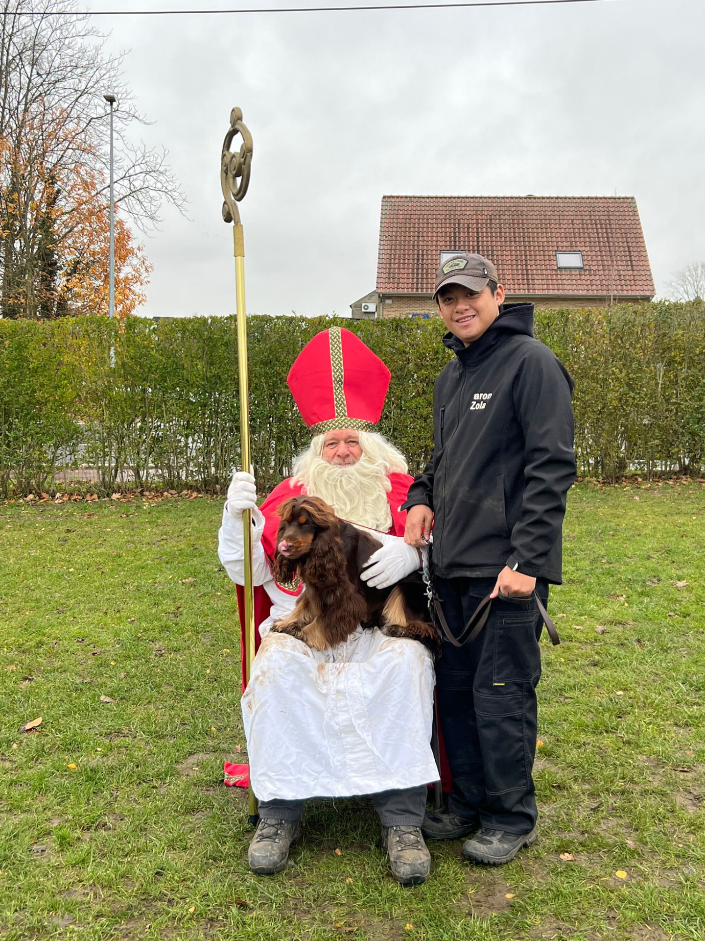Sinterklaas met een hond op schoot en zijn baasje